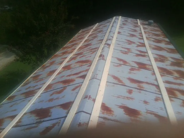 Rusted metal roof panels with new wood purlins before replacement — Storm Damage Roof Repair in Luebbering by Roofing Brothers