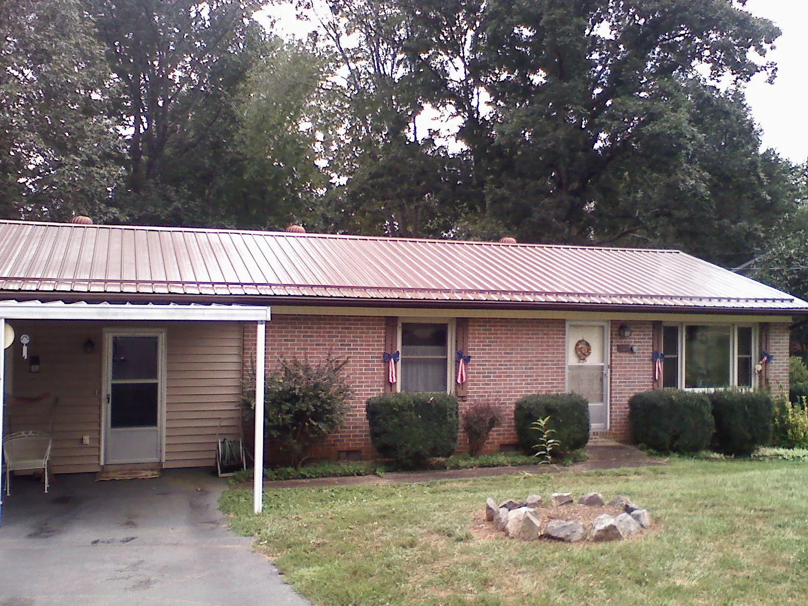 Bronze metal roof and carport on a brick ranch home — Roof Repair work by our crew in Luebbering