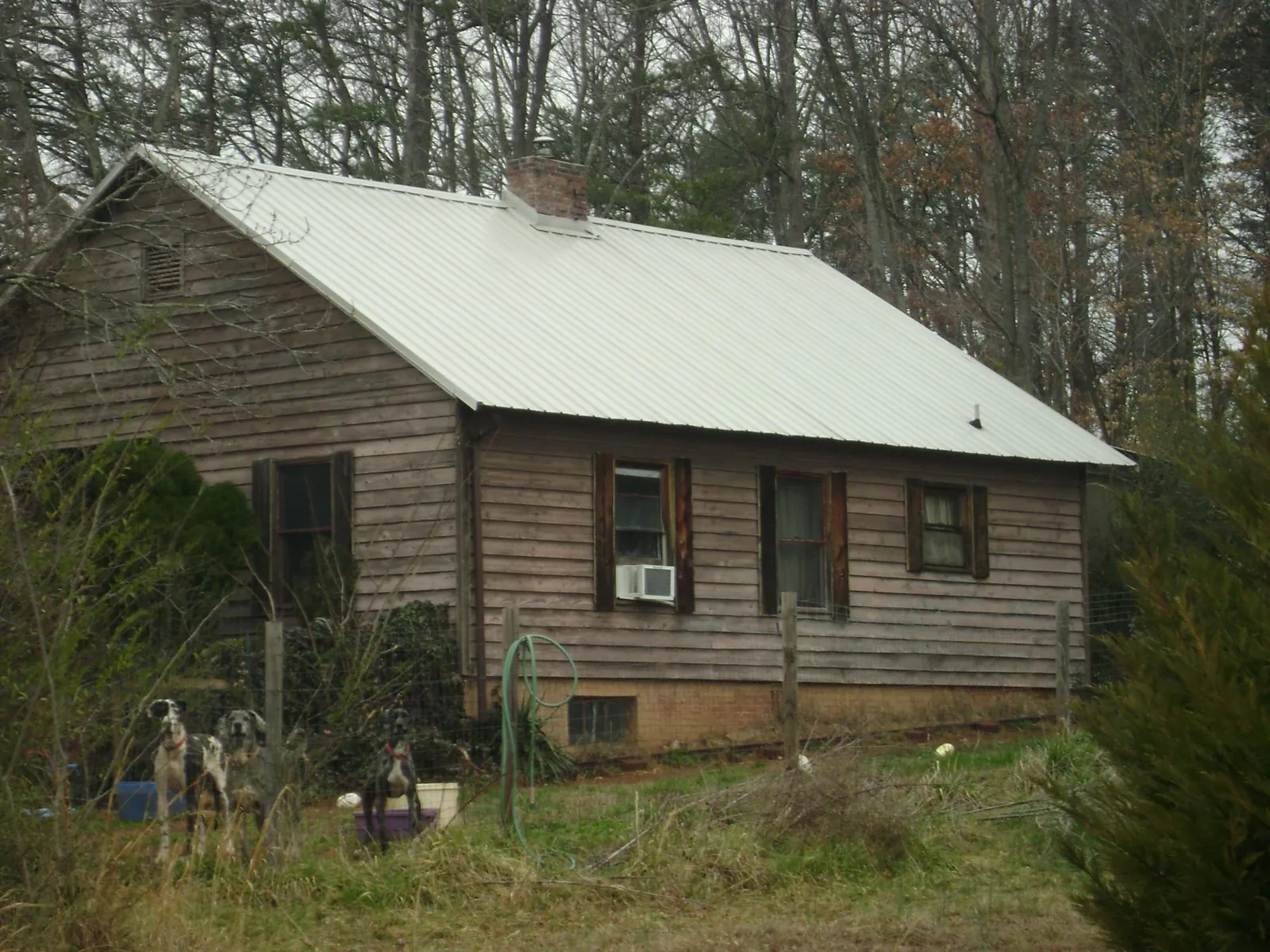 White metal roof on an old wood sided farmhouse, from a Metal Roof Installation job in Luebbering